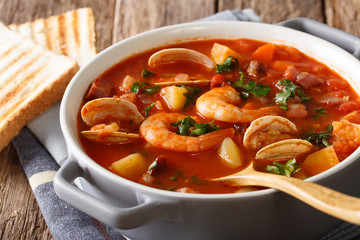 Homemade tomato clam chowder soup close-up in a saucepan. horizontal