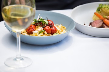 Lunch and wine glass on dining table at restaurant