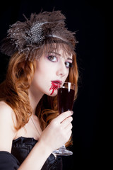 photo of beautiful young woman in vampire character with glass of wine
