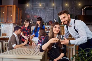 Meeting friends at the bar restaurant. A couple of men and  girl chat in cafe.