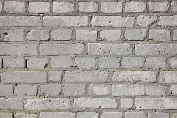 Picture of an old gray weathered brick wall, background or texture.