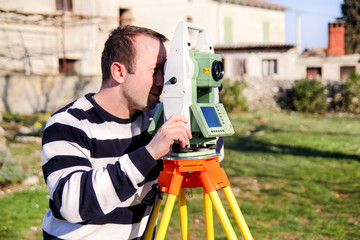 Man using of total station. Guy surveyor at work. Survey Instrument geodetic device, total station...