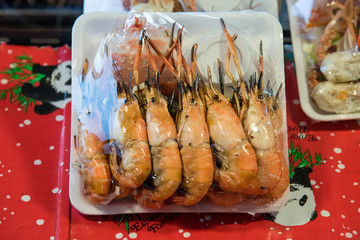 Wrapped Grilled shrimp with seafood sauce in foam food tray in food market at Bangkok, Thailand.