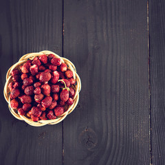 Berries of wild strawberries on a dark background.