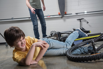 Obraz premium Father running to help wounded boy falling off bike