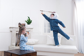 side view of boy and girl playing cosmonauts together