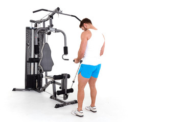 Fototapeta premium Athlete (bodybuilder) with is doing exercise on for certain groups of muscles in a simulator block. Isolated on white background.