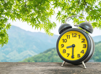 Closeup black and yellow alarm clock for decorate show half past eight o'clock or 8:30 a.m. on...