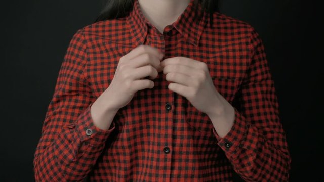 Woman unbuttoning shirt and showing bra