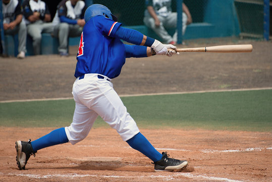 Men's league player in blue shirt swinging at a pitched ball