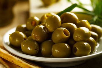 Fresh tasty greek green olives with grissini and fresh rosemar<. Closeup. Mediterranean food.