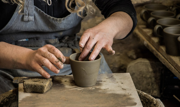 Woman potter at work creating some traditional cups of white clay, Margarites, Rethimno, Crete.