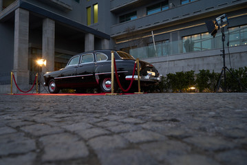 Black Retro car parked in old European city street.