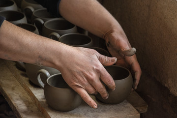 Woman potter at work creating some traditional cups of white clay, Margarites, Rethimno, Crete.