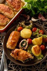 Spinach and cheese pork rolls (roulades) served with vegetables.