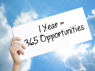 1 Year = 365 Opportunities Sign on white paper. Man Hand Holding Paper with text. Isolated on sky...