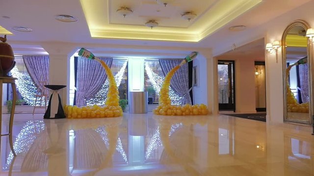 The design of a hall in the yellow balloons. Bunch of colored balloon decoration. Yellow background. Steadicam shot.
