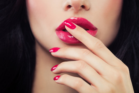 Female Lips and Nails Closeup. Pink Nail Polish, Lipgloss and Brown Hair. Beauty Concept