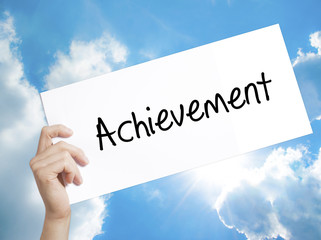 Achievement Sign on white paper. Man Hand Holding Paper with text. Isolated on sky background