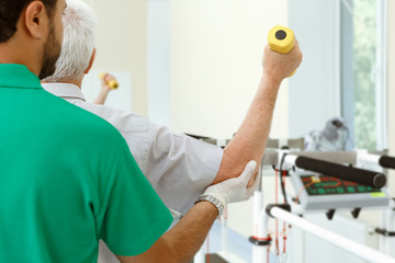 Young physiotherapist with his senior patient