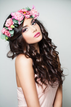 Spring Fashion Portrait of Beautiful Model Woman with Makeup, Flowers and Long Curly Hair