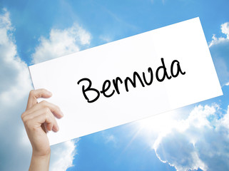 Bermuda Sign on white paper. Man Hand Holding Paper with text. Isolated on sky background