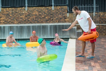 Lifeguard helping swimmers at poolside