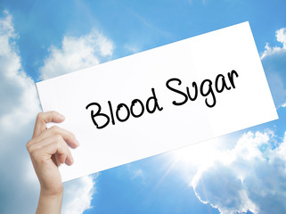 Blood Sugar Sign on white paper. Man Hand Holding Paper with text. Isolated on sky background