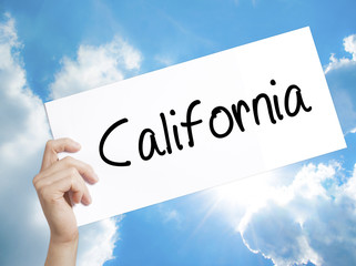 California Sign on white paper. Man Hand Holding Paper with text. Isolated on sky background