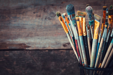 Bunch of paint brushes in a artist studio. Copy space for text. Retro toned photo.
