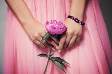 Beautiful Peony Flower in Female Hands on Lacy Prom Skirt. Pink Background © millaf (Nemchinova)