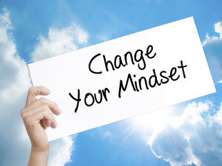 Change Your Mindset Sign on white paper. Man Hand Holding Paper with text. Isolated on sky background.