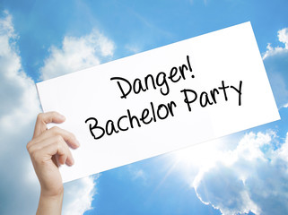 Danger! Bachelor Party Sign on white paper. Man Hand Holding Paper with text. Isolated on sky background