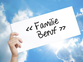 familie beruf (Family Occupation in German) Sign on white paper. Man Hand Holding Paper with text. Isolated on sky background