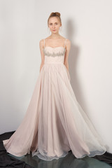 Fototapeta premium Fantastic fashion woman in fluttering beige dress