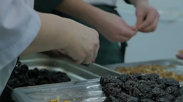 Mixed ethnicity team of professional chefs preparing and cooking food in a commercial kitchen. In slow motion.