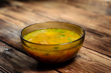 Vegetable soup in a glass bowl on wooden table