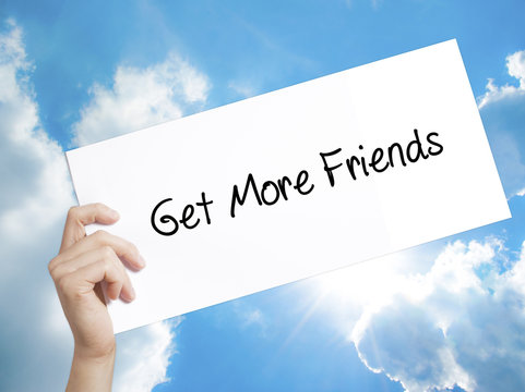 Get More Friends Sign on white paper. Man Hand Holding Paper with text. Isolated on sky background