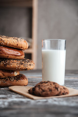 Pastries on dark wooden table with milk and cookie