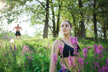 Naklejka na ściany i meble Beautiful fit young woman in sporty outfit in green tall grass.