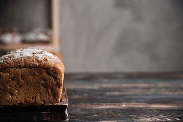 Bread with flour on dark wooden table