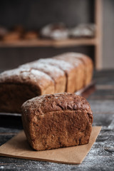Bread with flour on dark wooden table