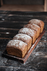 Bread with flour on dark wooden table