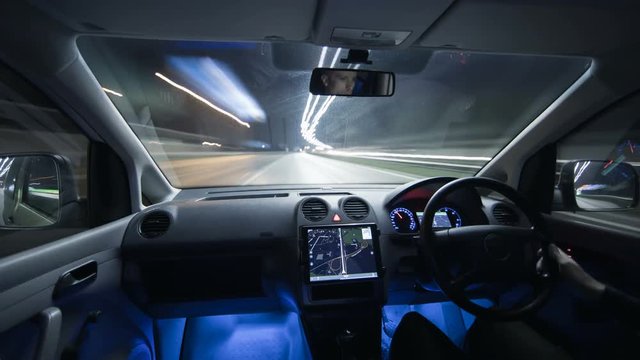 The man drive a car in the rainy city with a navigator. Inside view. Hyperlapse. Wide angle