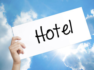 Hotel Sign on white paper. Man Hand Holding Paper with text. Isolated on sky background