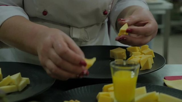 Chef finalizing a cheese in a kitchen. Close up hands no faces Chef prepare dinner using organic produce. Slow motion