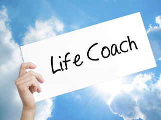 Life Coach Sign on white paper. Man Hand Holding Paper with text. Isolated on sky background