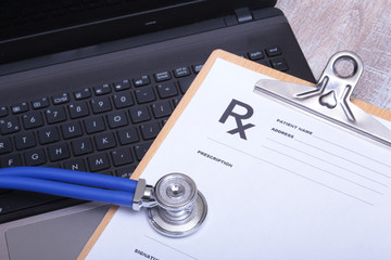 Prescription form with laptop computer and stethoscope