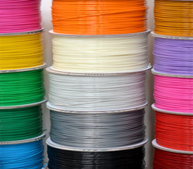 Reels of plastic for 3D printer close-up. Reels of filament wire for 3D printer different colors....