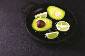 Avocado, sea salt and lime slices on stone background